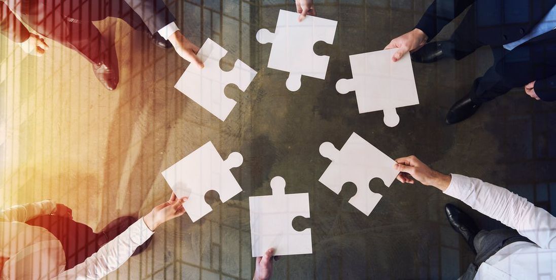 Jigsaw pieces being held in the middle of a circle