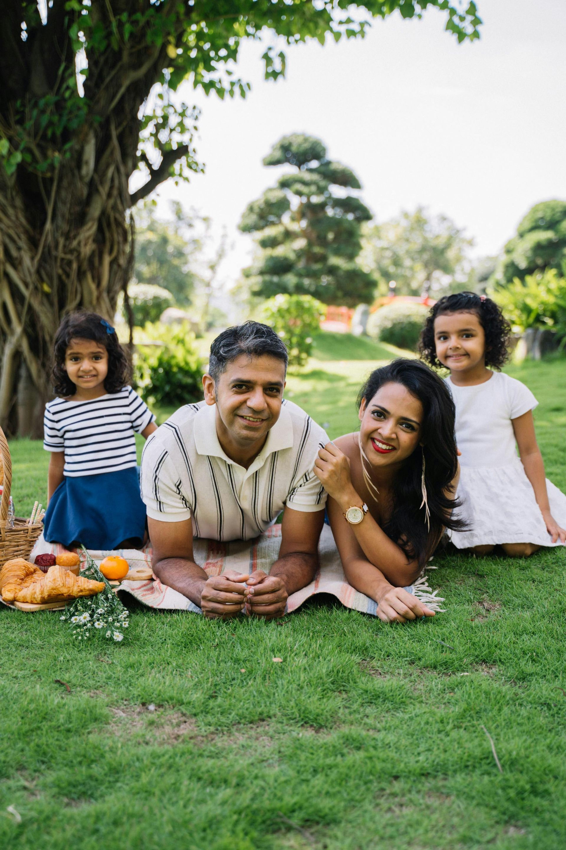 A smiling family is lying in the grass
