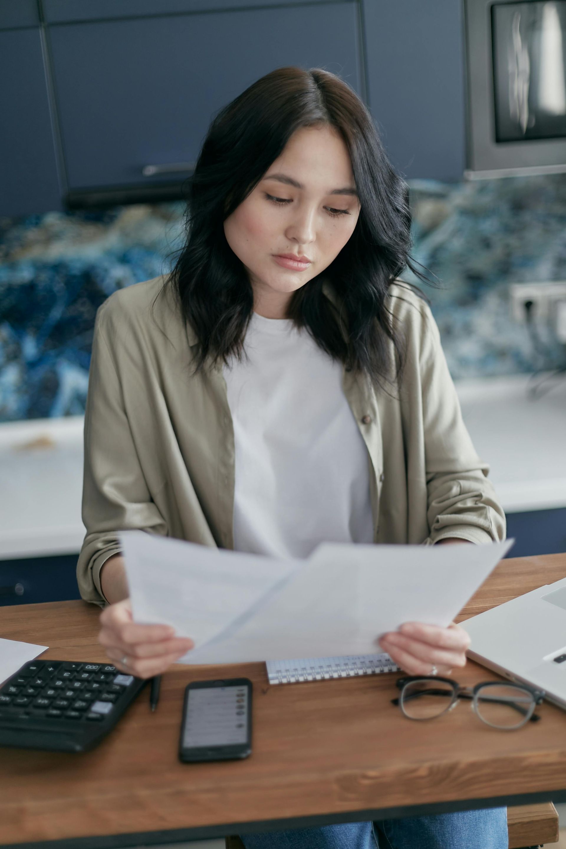 A woman is sitting at a table reviewing papers