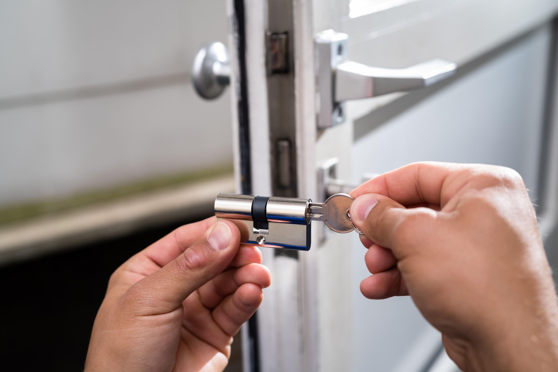 a person is fixing a door lock with a key .