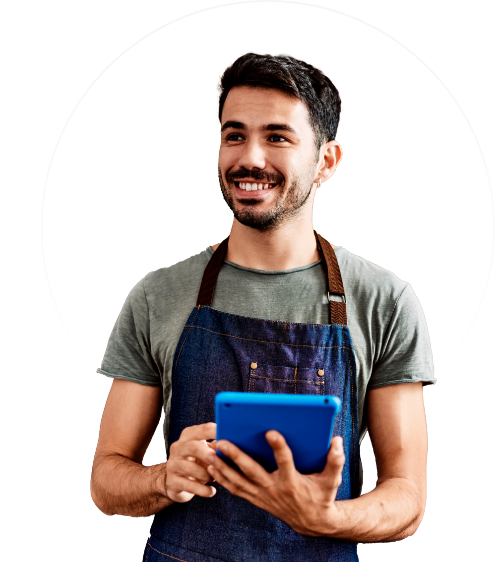 Persona sonriente con camisa y delantal grises sosteniendo una tableta azul sobre un fondo blanco.