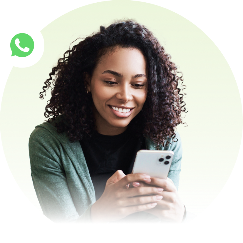 Mujer sonriente usando un teléfono inteligente, con el icono de WhatsApp en la esquina.
