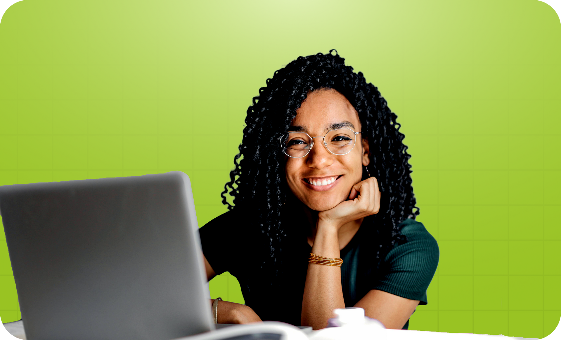 Persona sonriendo junto a un portátil sobre un fondo verde brillante.