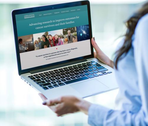 Woman holding laptop, viewing website with text and images.