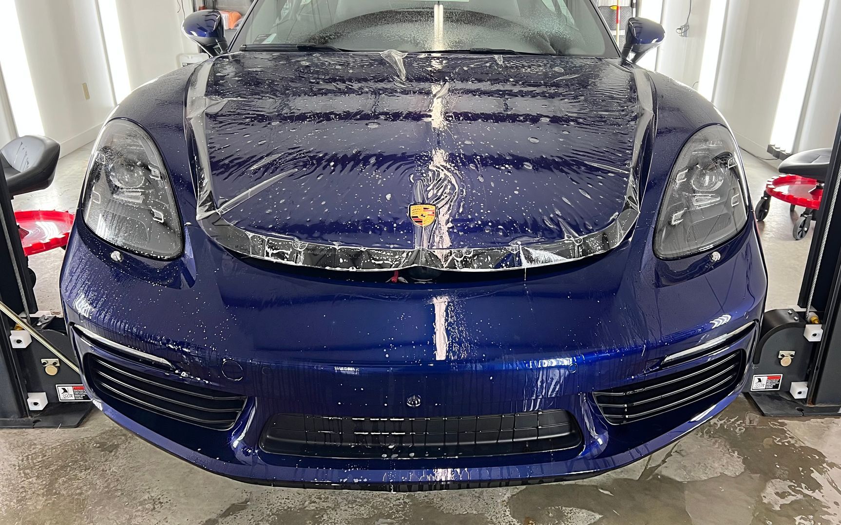 A man is spraying water on a piece of plastic.