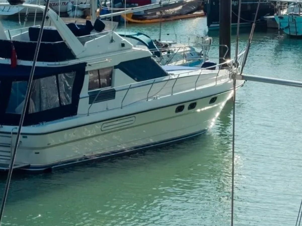 White cabin cruiser docked in a marina.