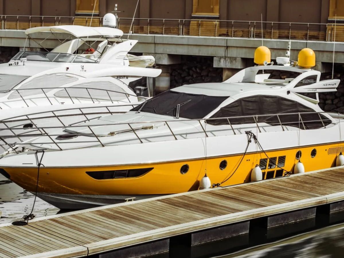 Motor yacht docked at a marina among other boats.