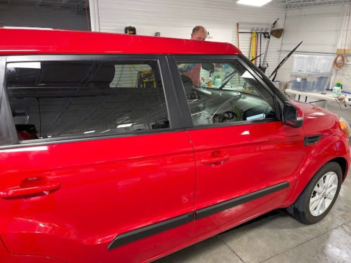 Red Kia Soul inside the Wellstone Auto Spa shop.