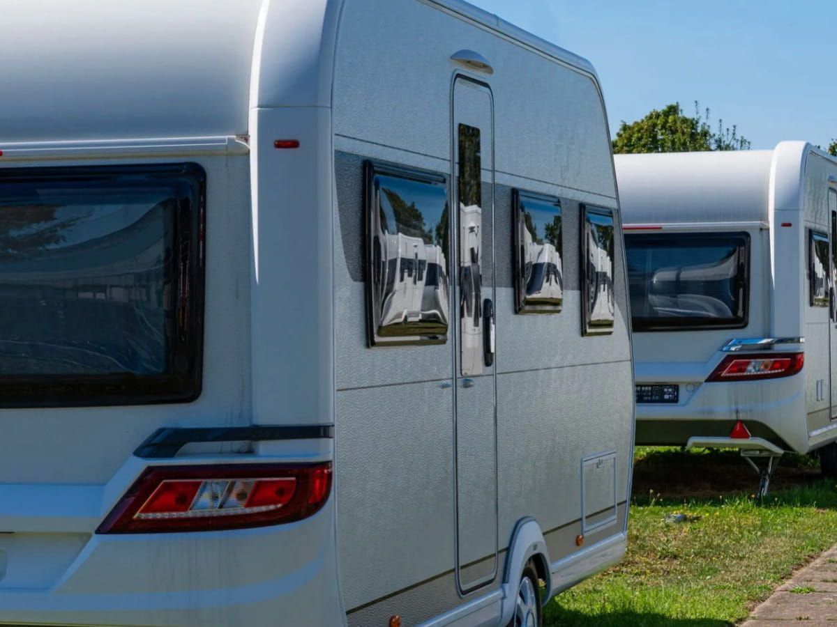 Travel trailers parked in an outdoor RV storage area.