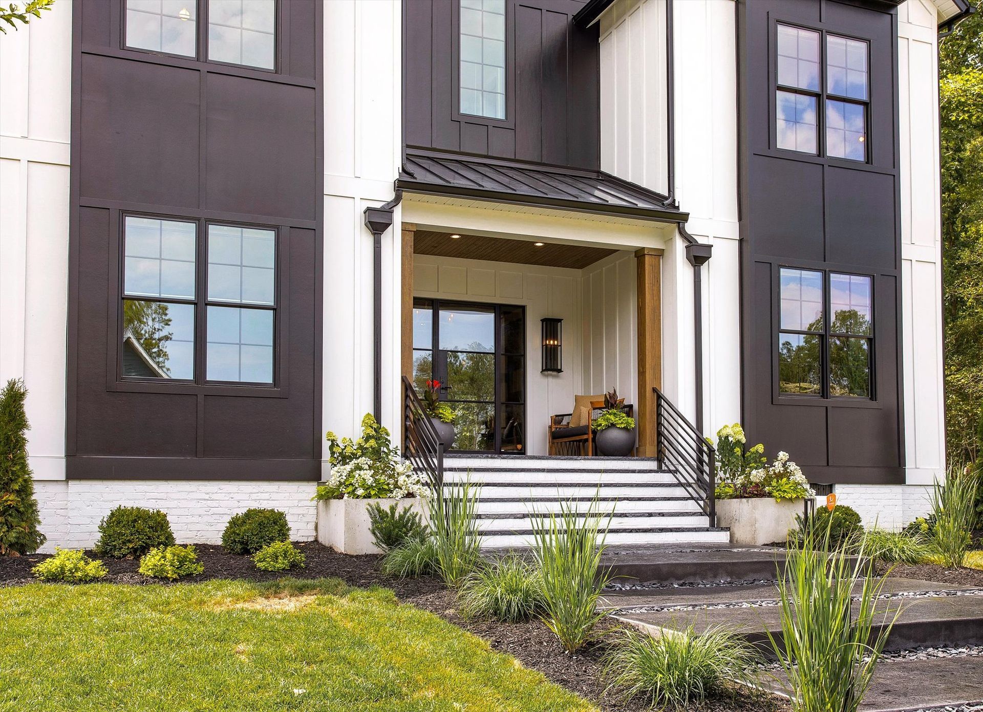 A black and white house with a porch and stairs