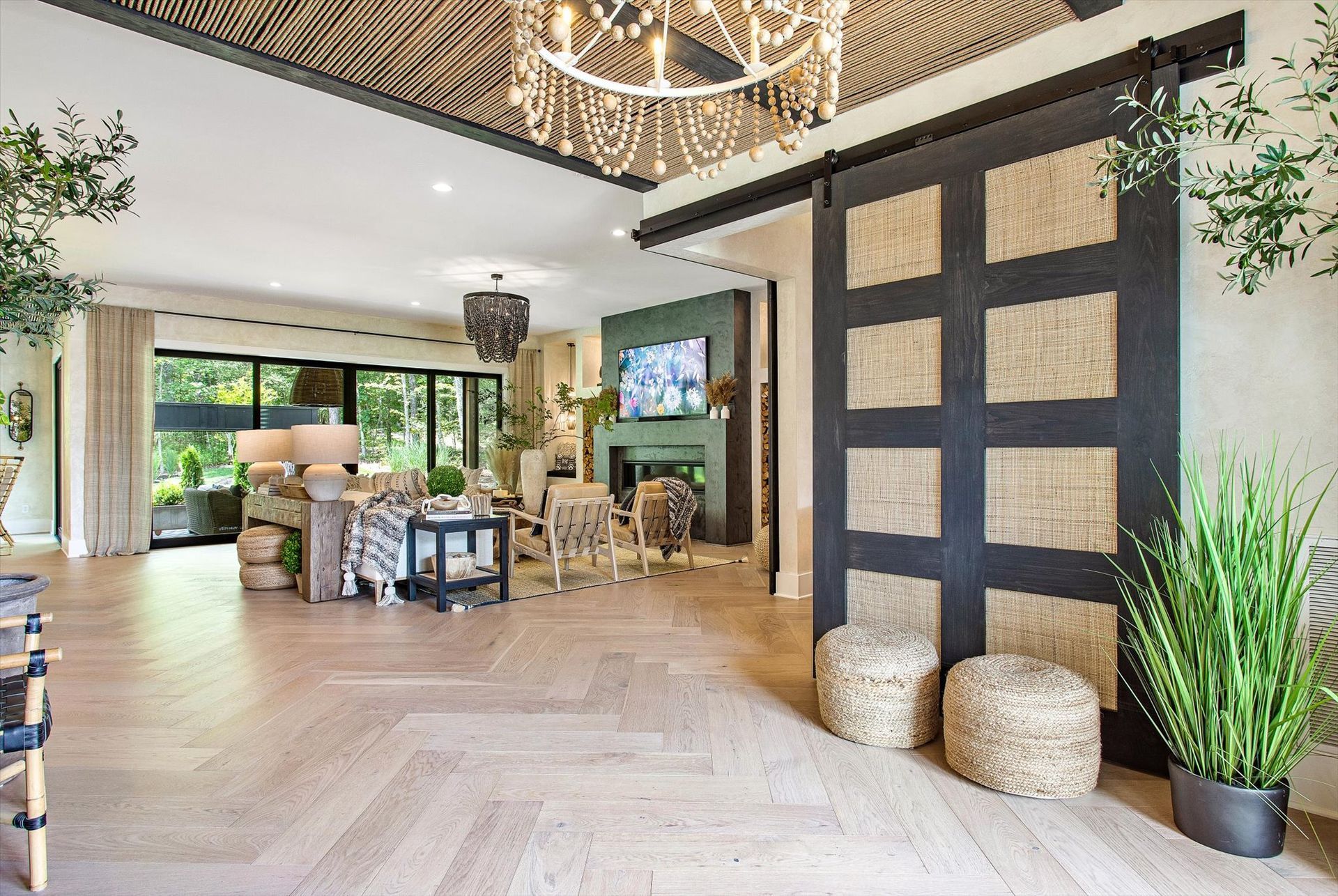 A living room with a sliding barn door and a chandelier.