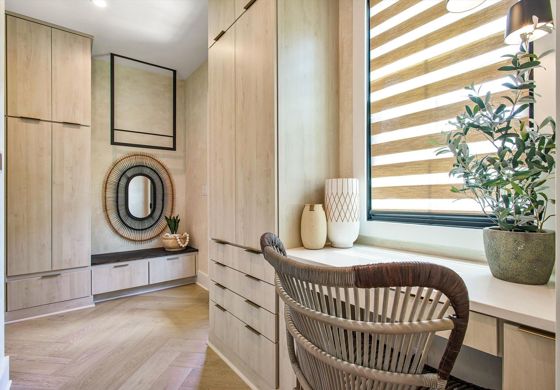 A room with a desk and chair in front of a window.