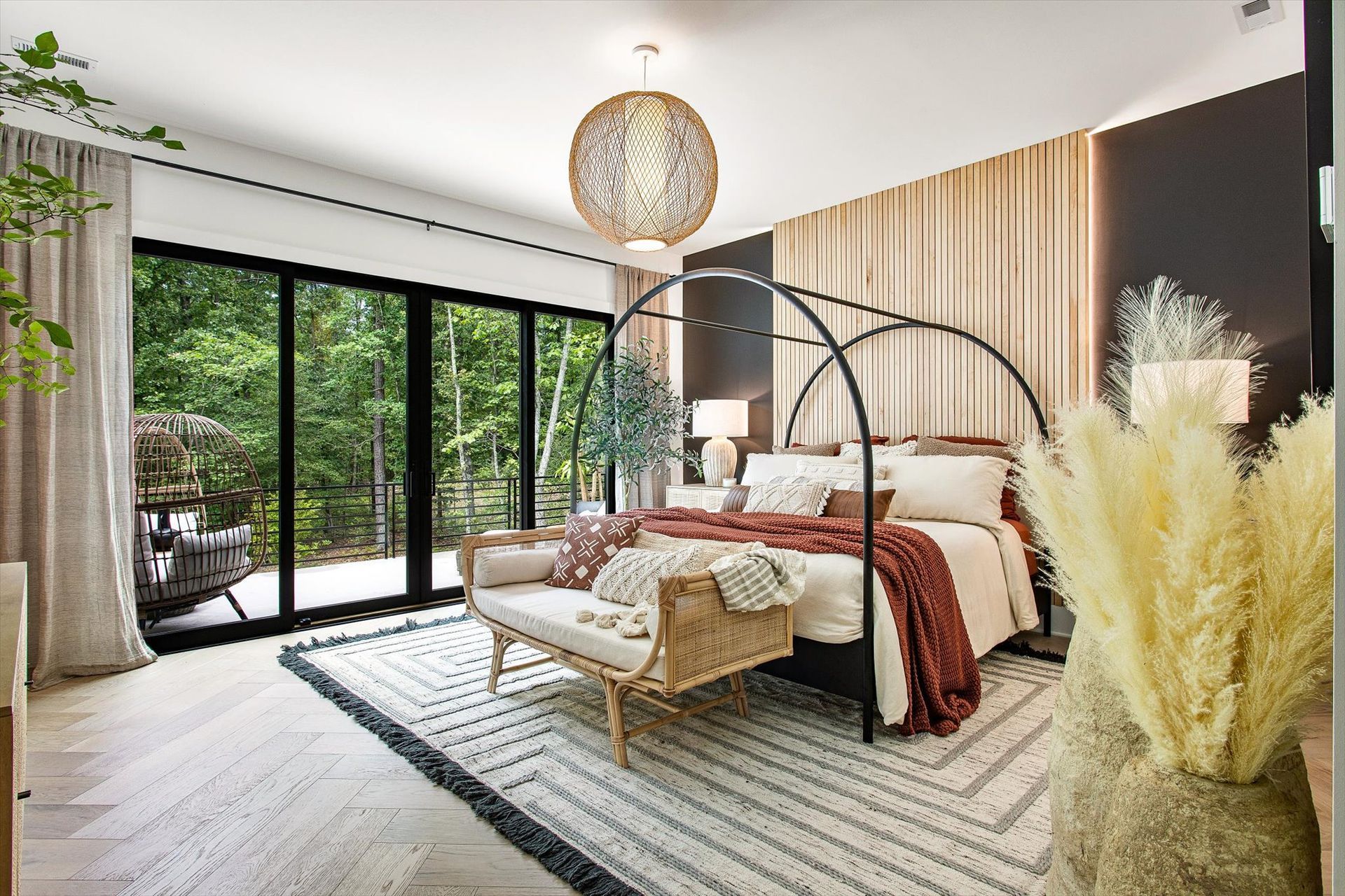 A bedroom with a canopy bed and sliding glass doors.
