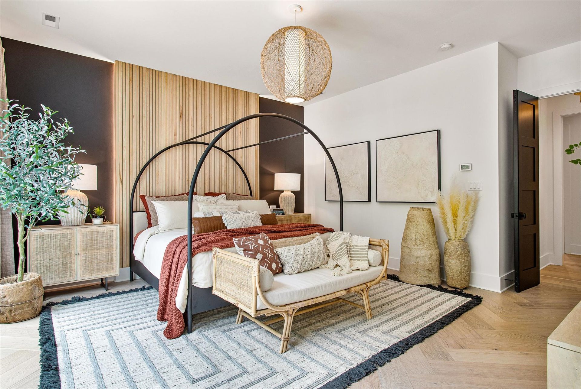 A bedroom with a canopy bed and a bench.
