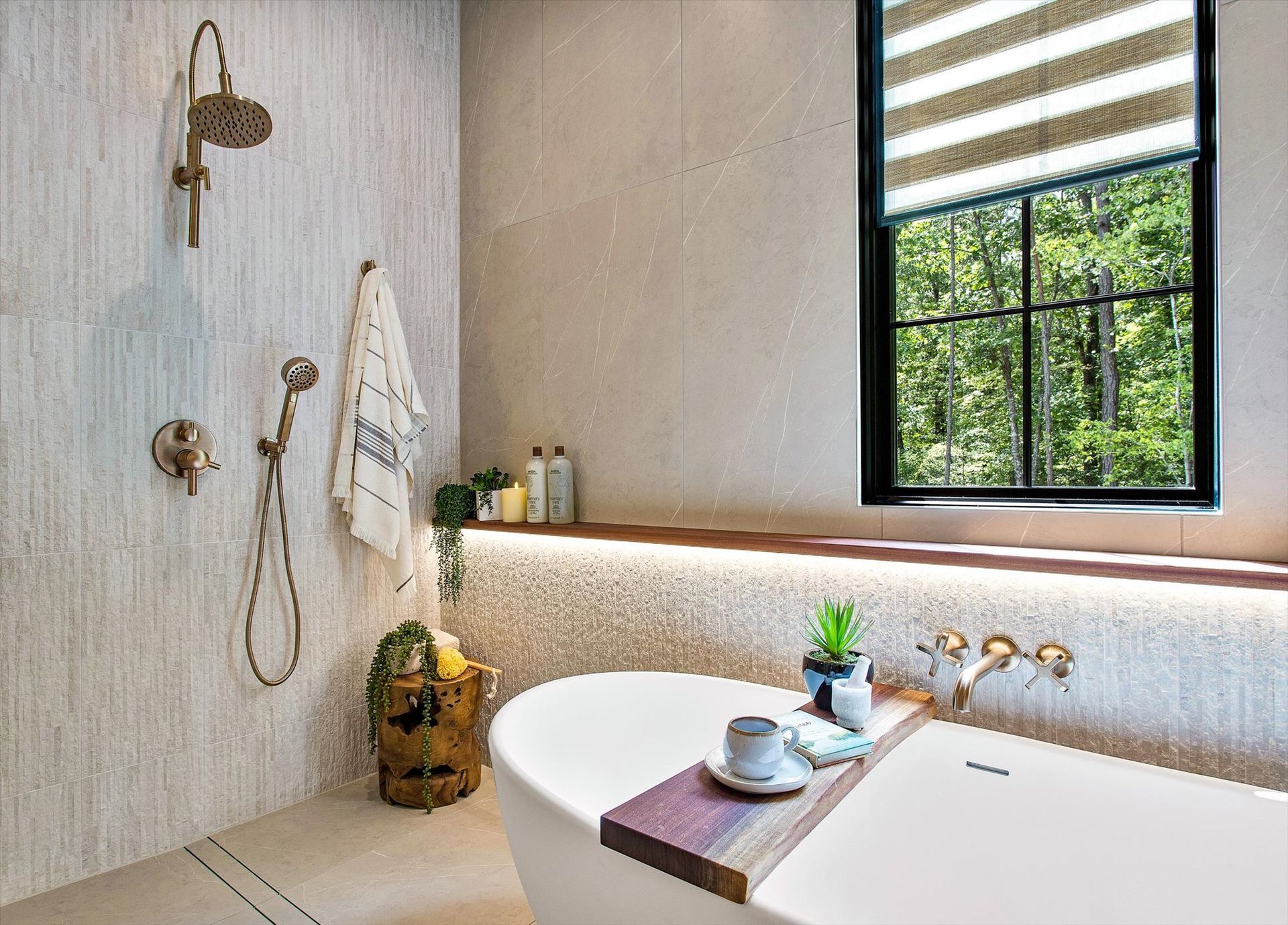 A bathroom with a tub , shower , and window.
