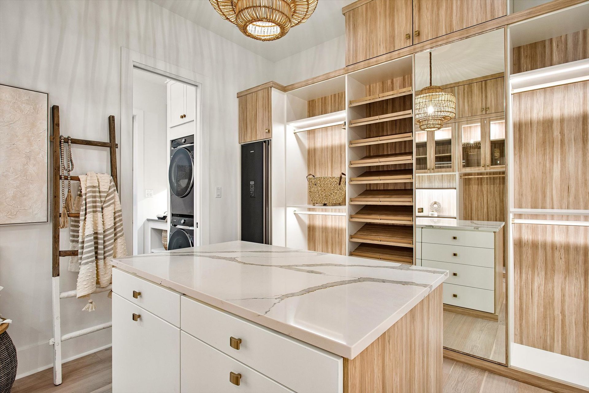 A walk in closet with a large island in the middle of it.