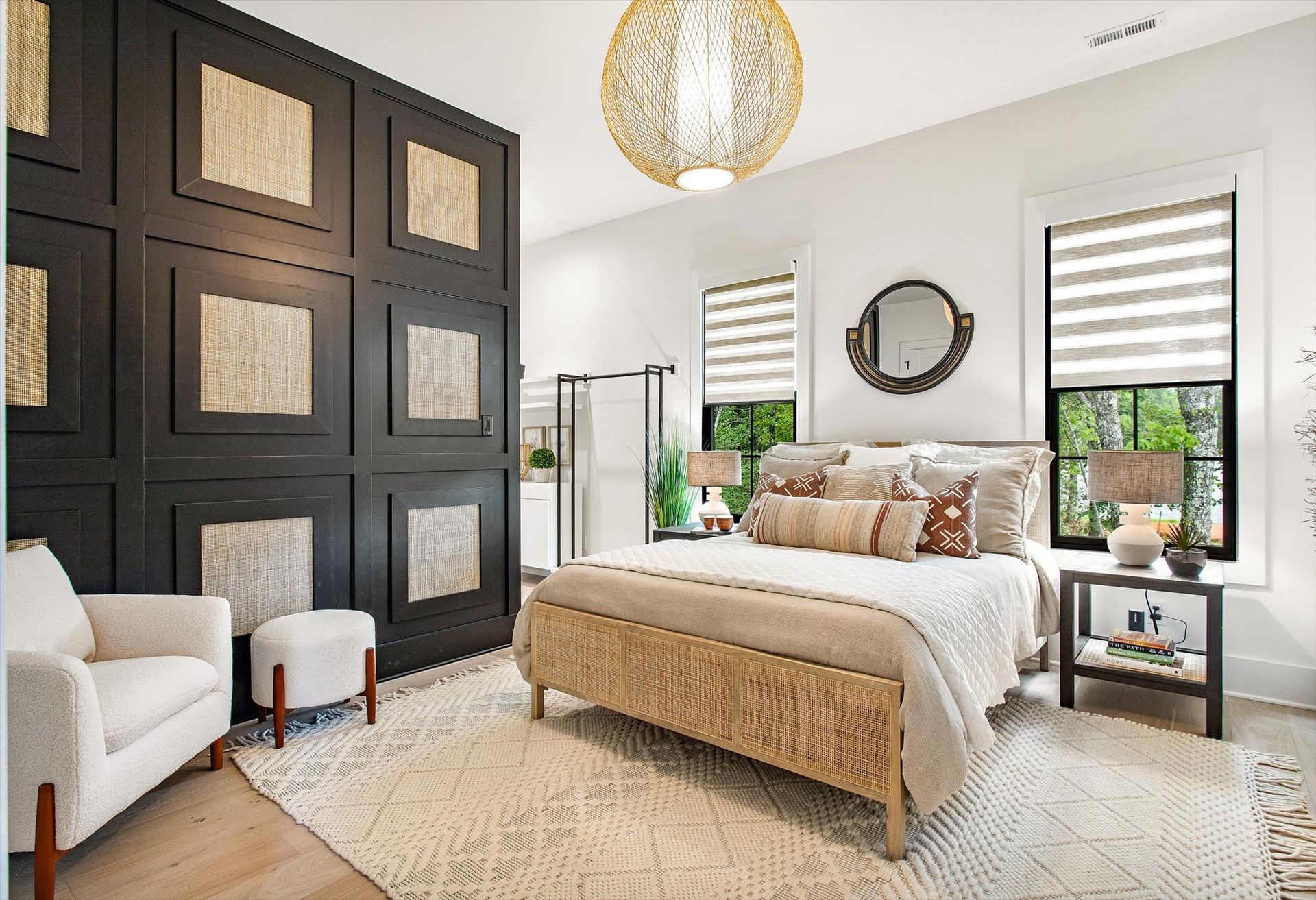 A bedroom with a bed , chair , nightstand , and window.