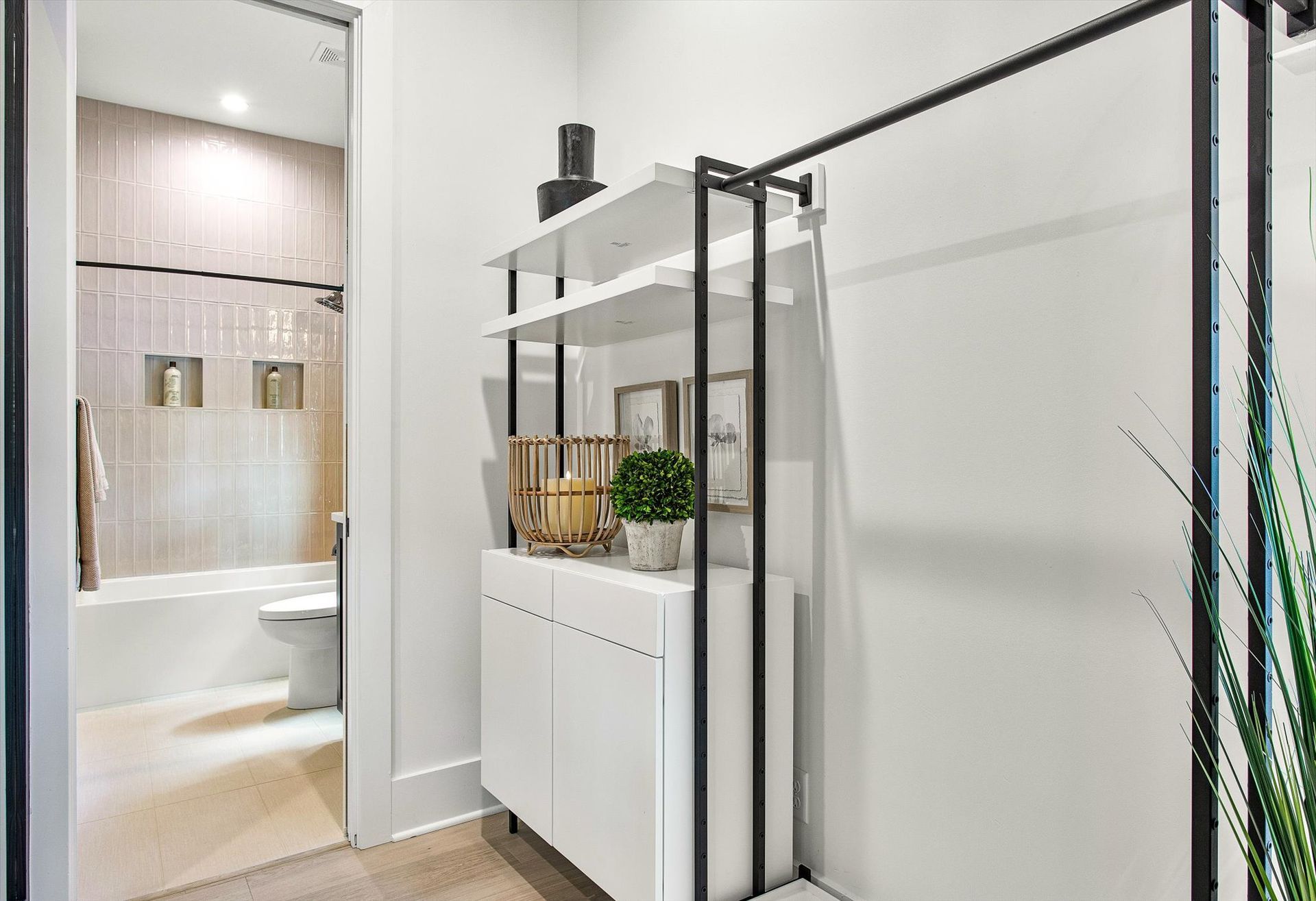 A hallway in a house with a closet and a bathroom.