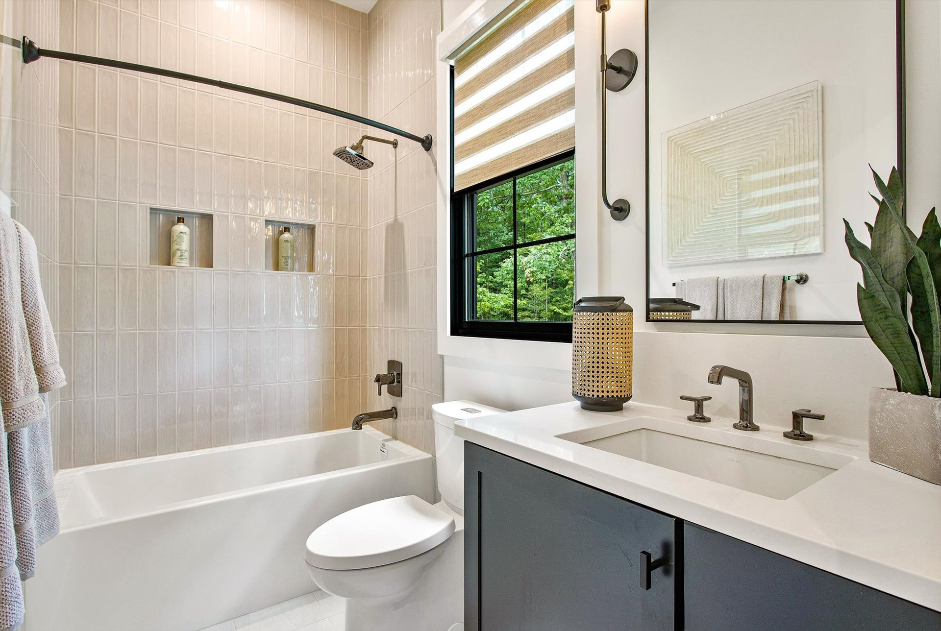 A bathroom with a tub , toilet , sink and mirror.