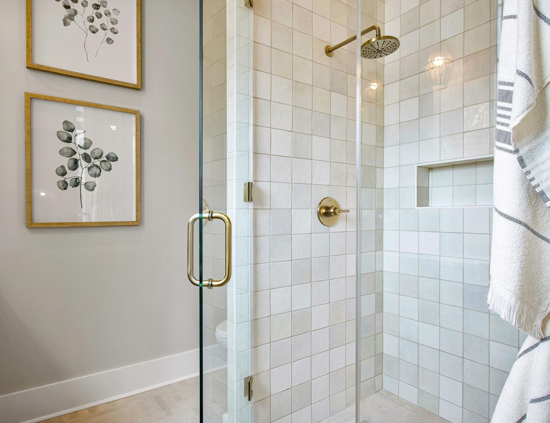 A bathroom with a walk in shower with a glass door.