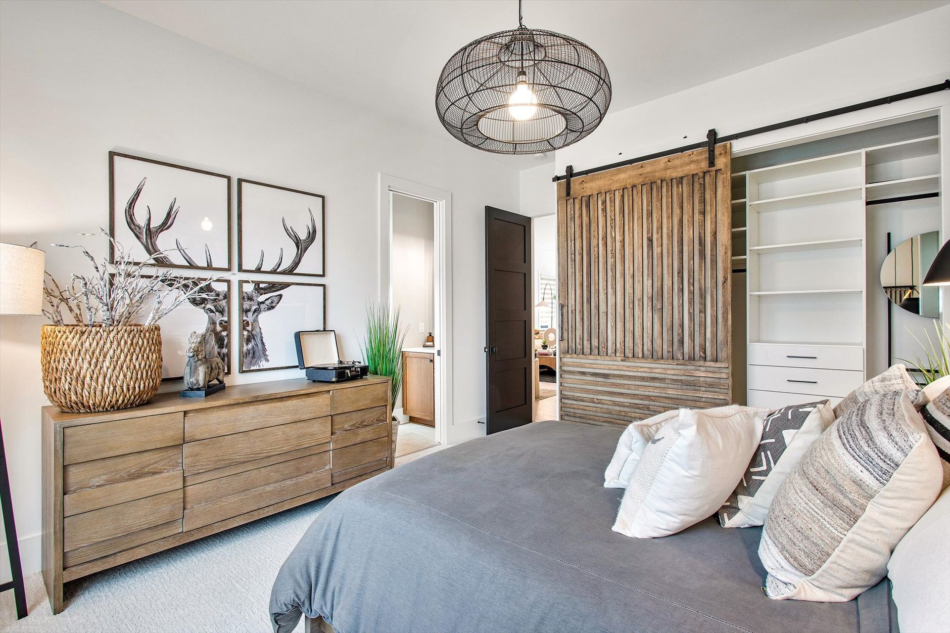 A bedroom with a bed , dresser and sliding barn door
