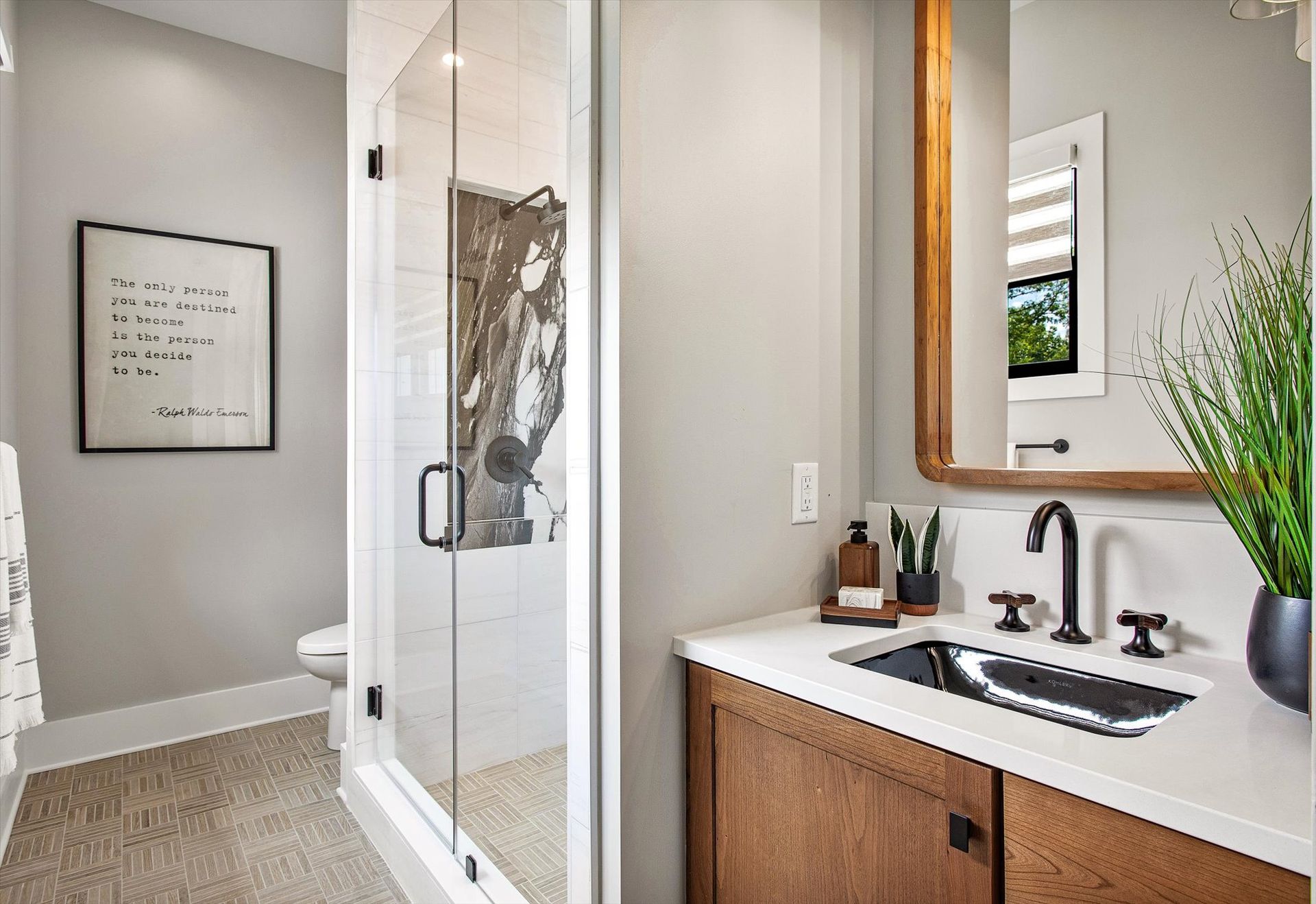 A bathroom with a sink , mirror and walk in shower.