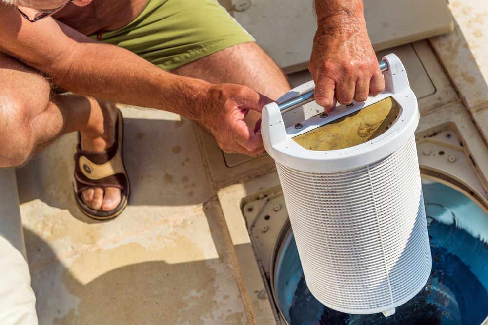 A Man is Cleaning a Pool Filter in a Swimming Pool — Figleaf Pool Products in Coolalinga , NT