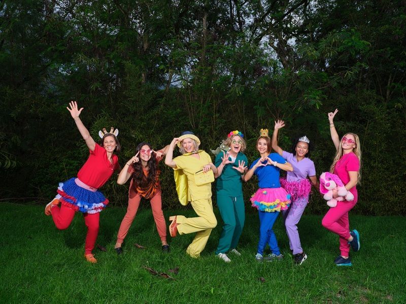 A group of women are posing for a picture in a field.