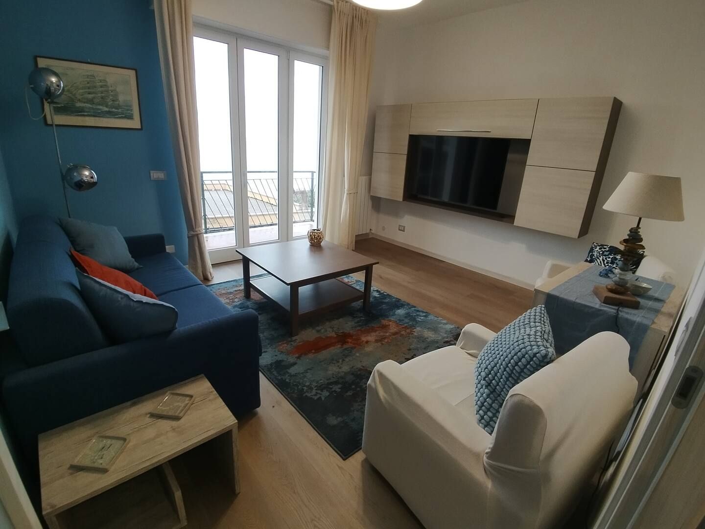Un soggiorno con un divano blu e una sedia bianca