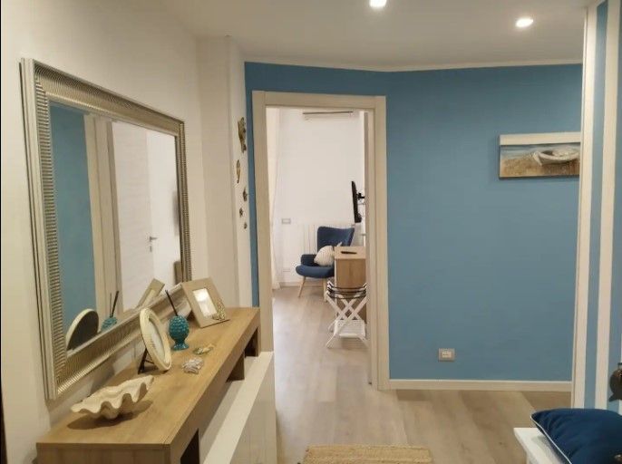 Un corridoio con pareti blu e uno specchio