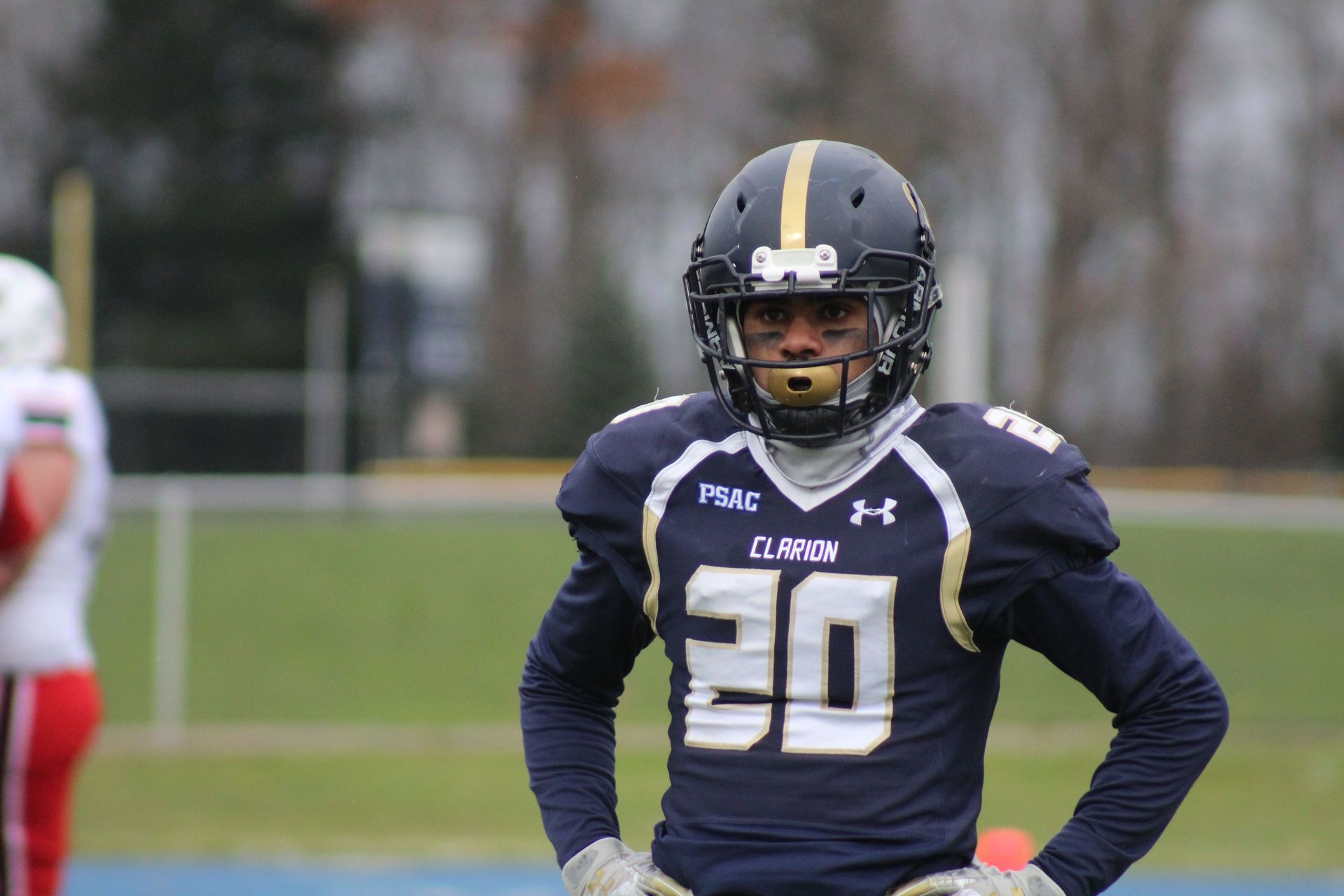 Football player in navy uniform #30 standing on the field during practice