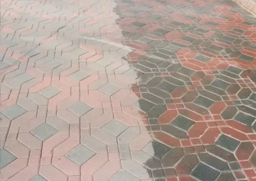 Wet hexagonal pavement tiles in pink, gray, and dark red patterns.