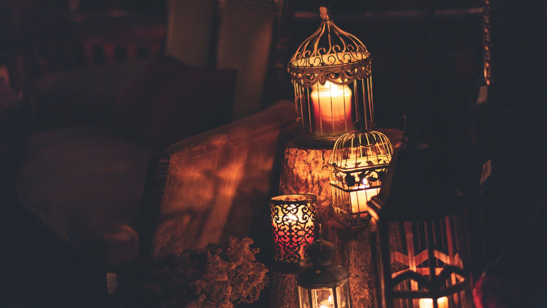 Candlelit lanterns on wood, creating a warm, dim ambiance.