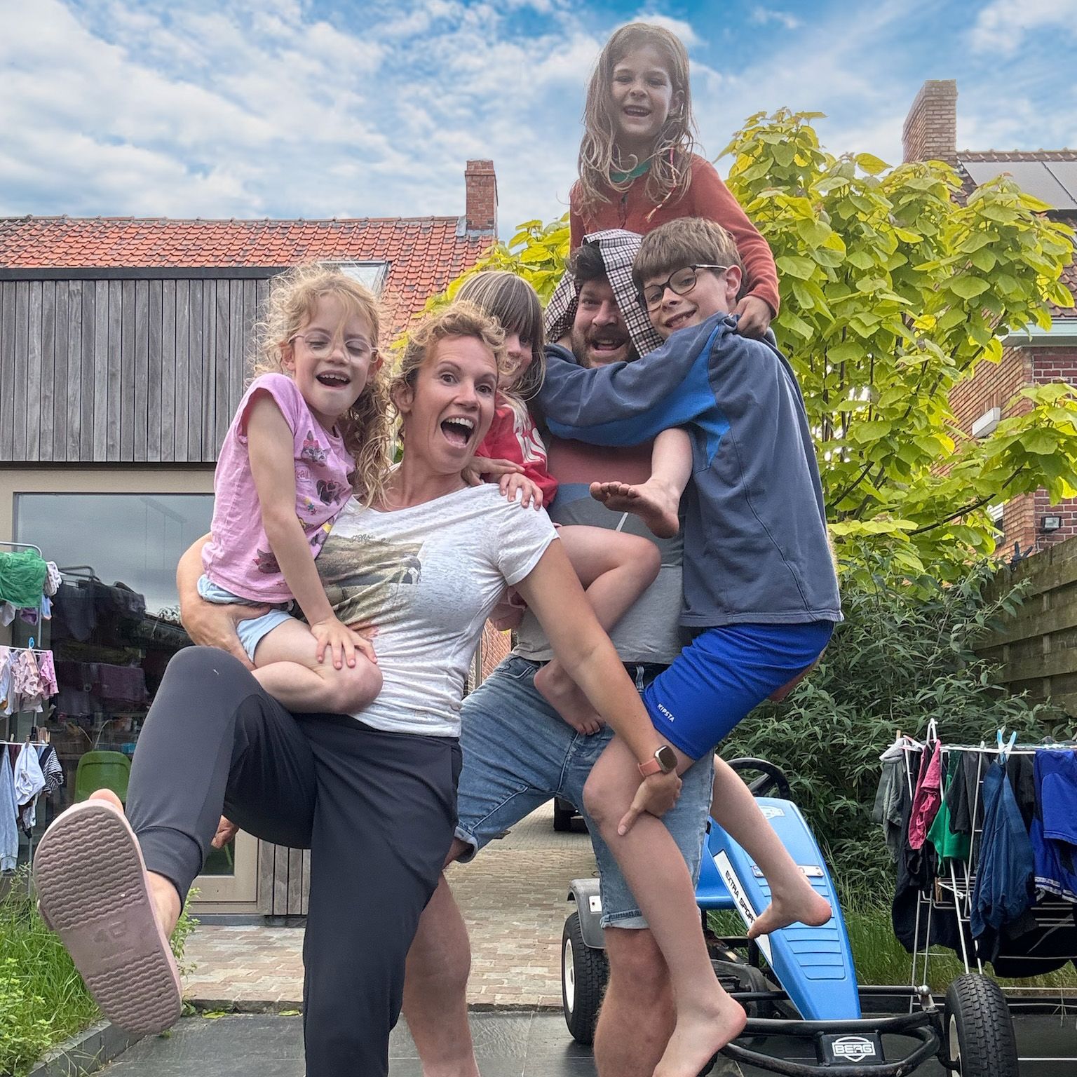 Een man draagt ​​een vrouw en twee kinderen op zijn schouders.