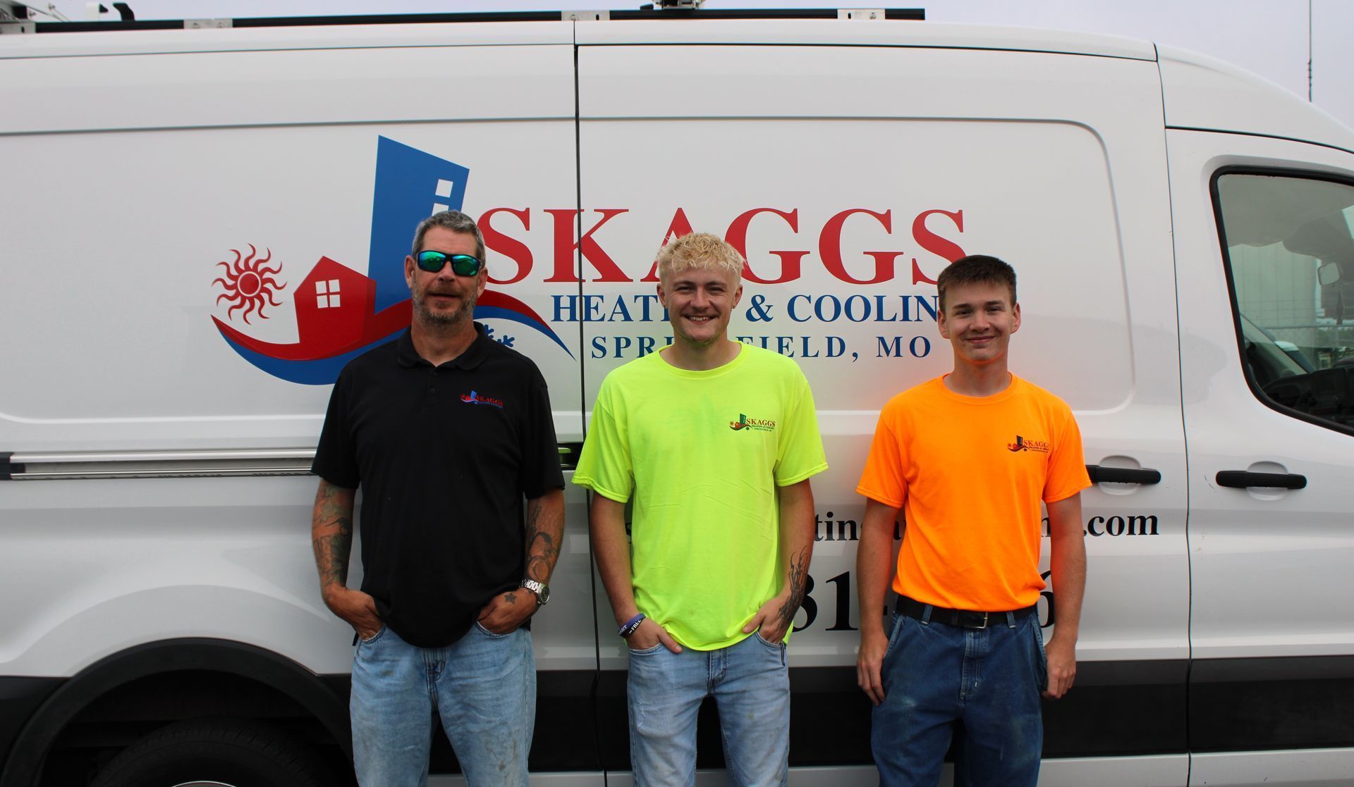 Three men standing in front of a Skaggs Heating & Cooling service van