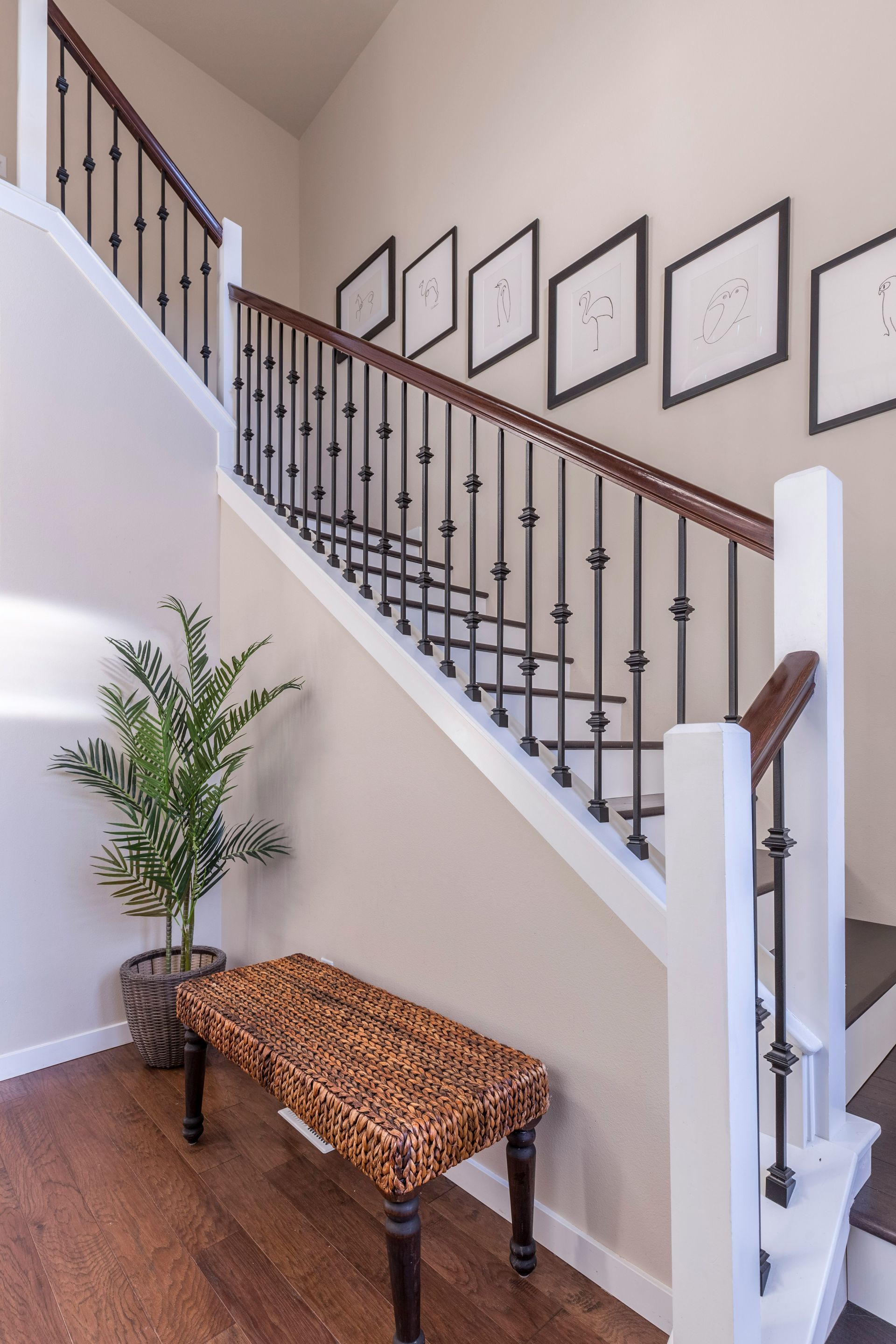 A staircase with a wicker bench and a plant