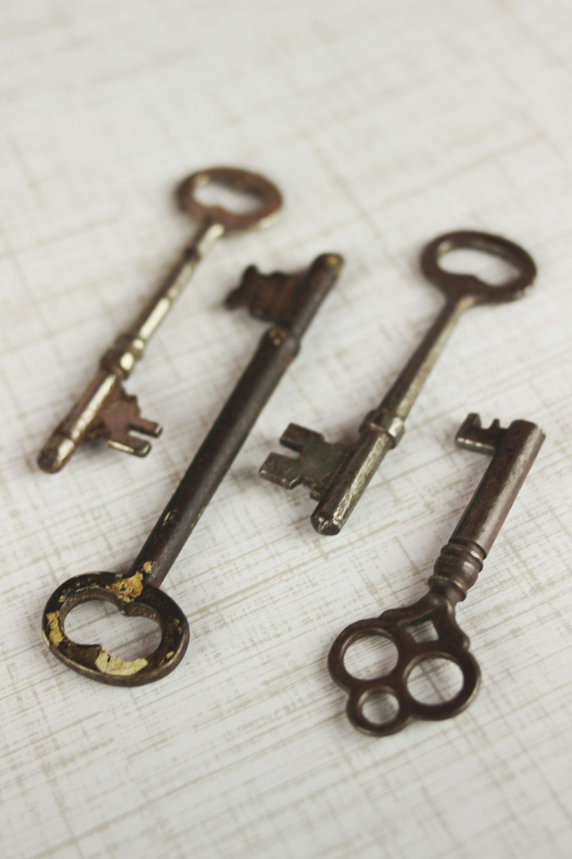 Four old keys are laying on a table