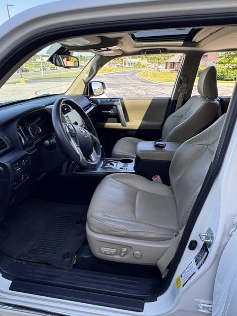 Empty car interior with gray leather seats and open driver’s door.