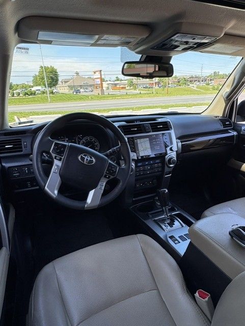 Toyota SUV interior with steering wheel, center console, and front seats, viewed from the back seat