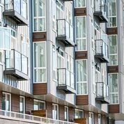 Modern apartment building with rows of glass-enclosed balconies and windows