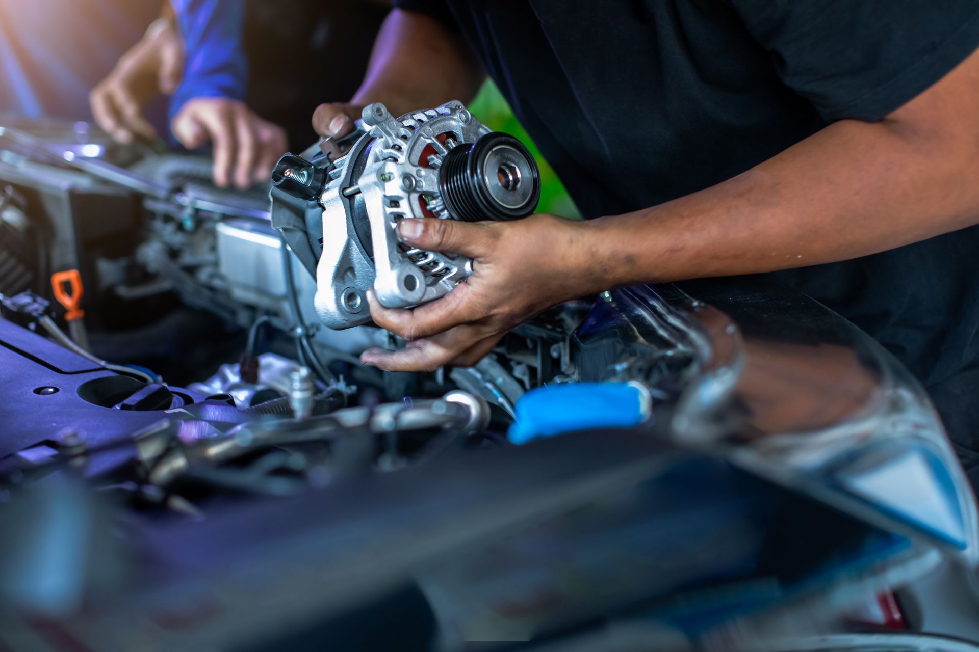 A man is working on the engine of a car.