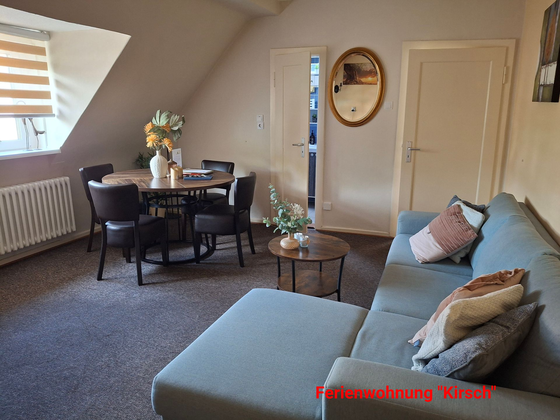 Woonkamer met eettafel, bank en een raam.