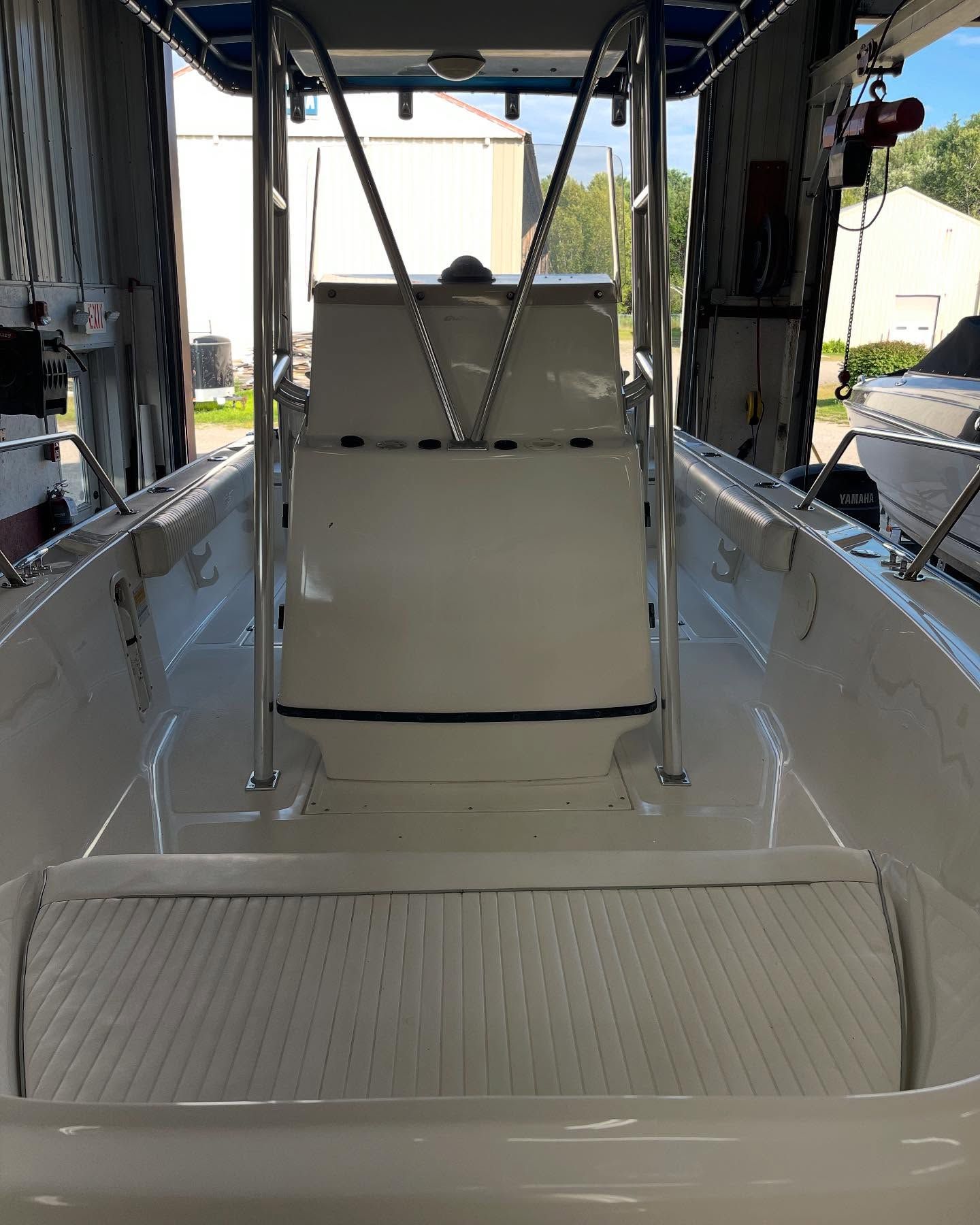 A white boat is parked in a garage.