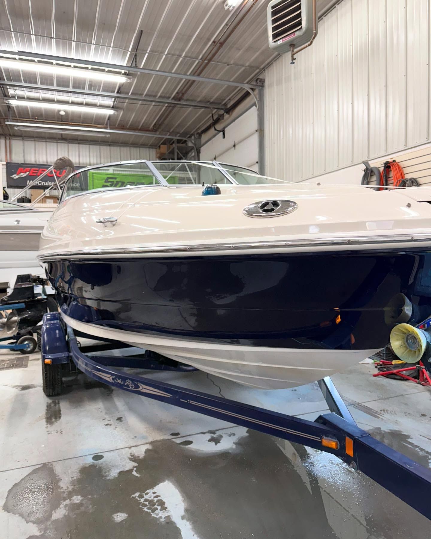 A boat is parked on a trailer in a garage.