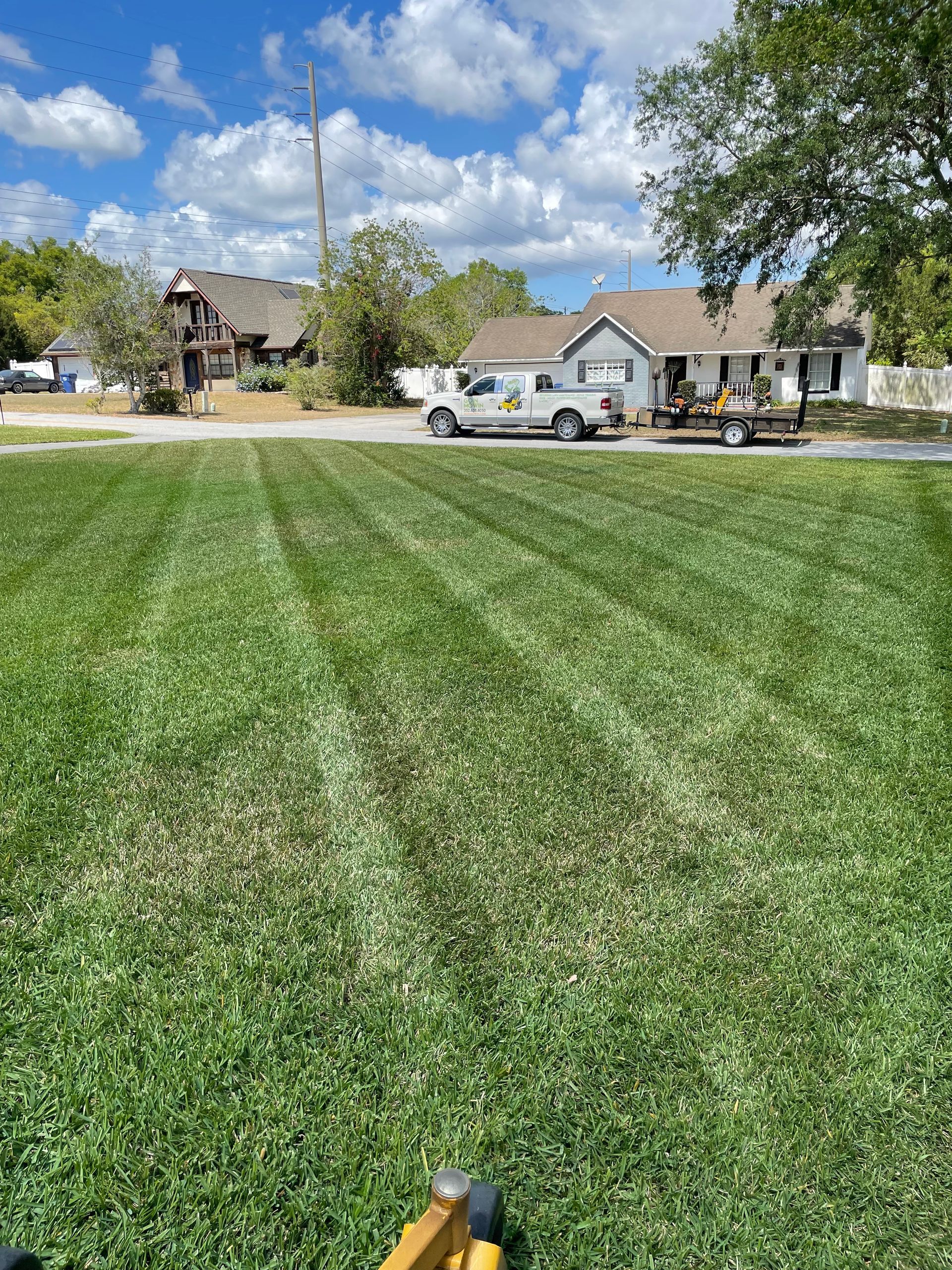 a lawn mower is parked in front of a house