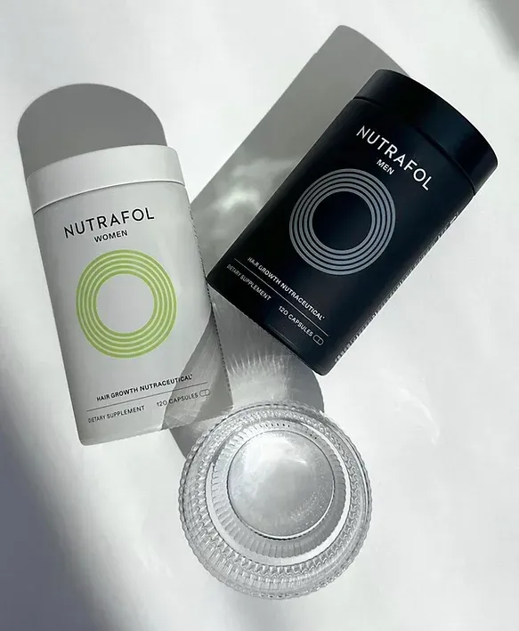 Two containers of nutrafol are sitting next to each other on a table.