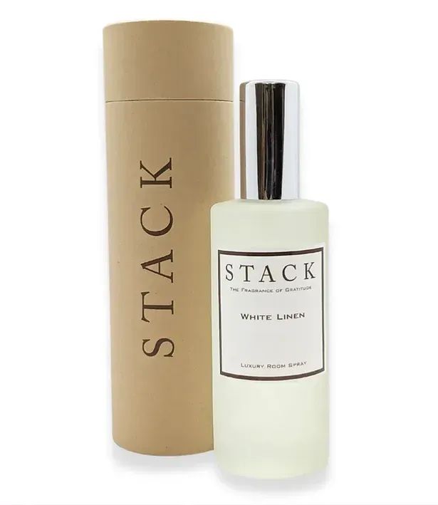 A bottle of stack white linen next to a cardboard tube.