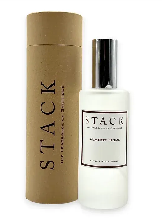 A bottle of stack perfume next to a cardboard tube