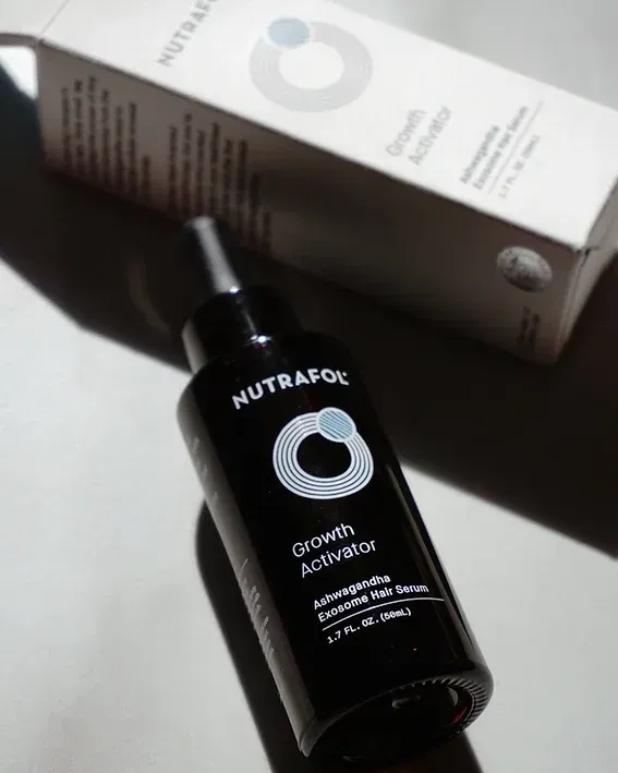 A black bottle of nutrafol growth activator next to a box