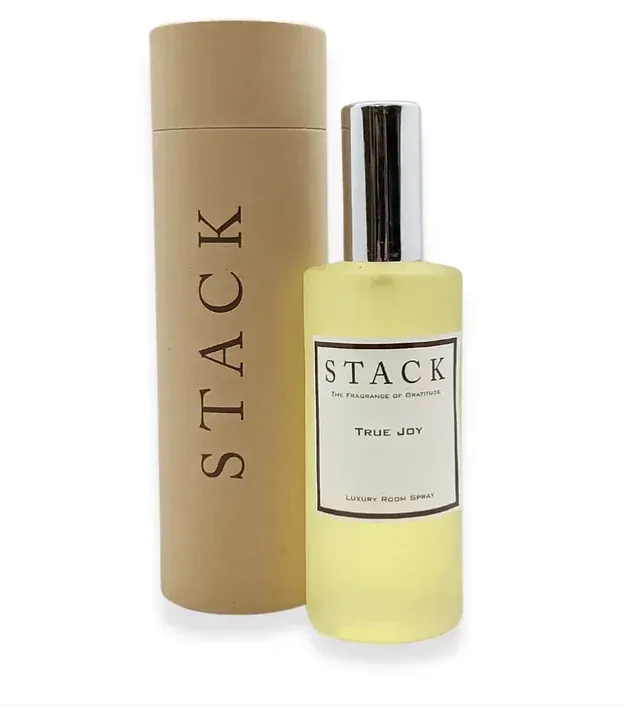 A bottle of stack perfume next to a cardboard tube